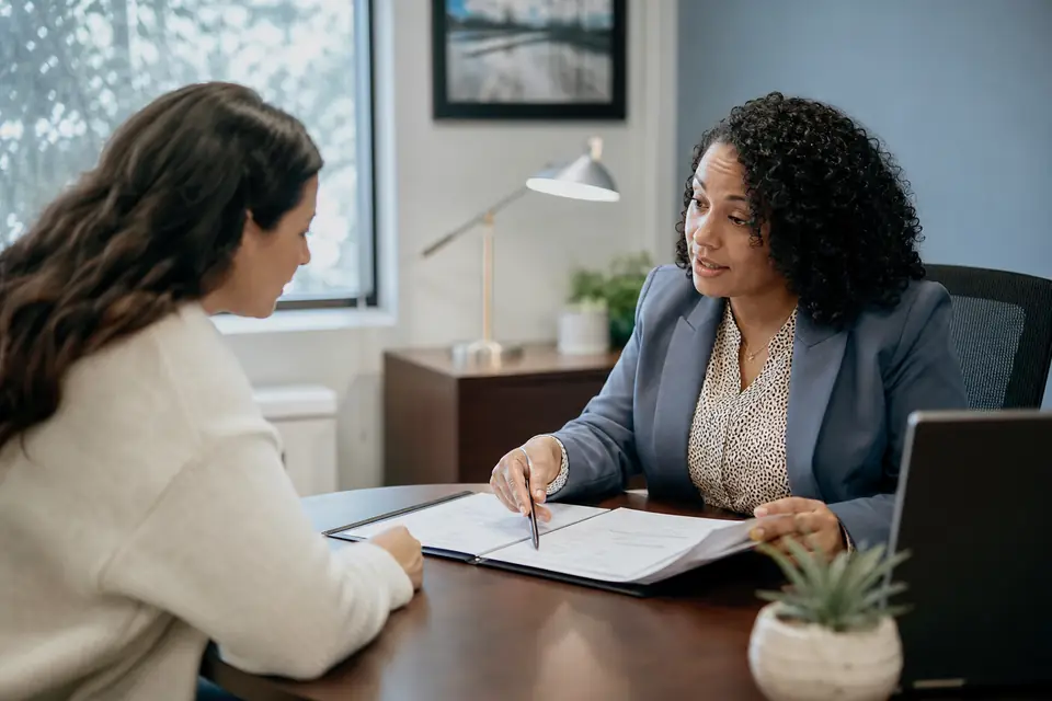 Woman and a loan officer reviewing documents at a credit union desk